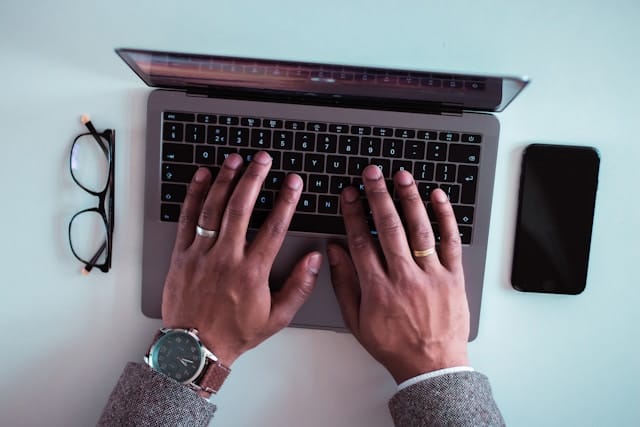 man typing an email on laptop